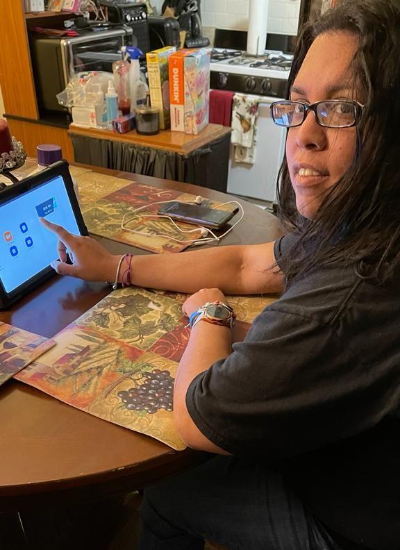 Melanie Figueroa uses her Galaxy Tab device while sitting at a table