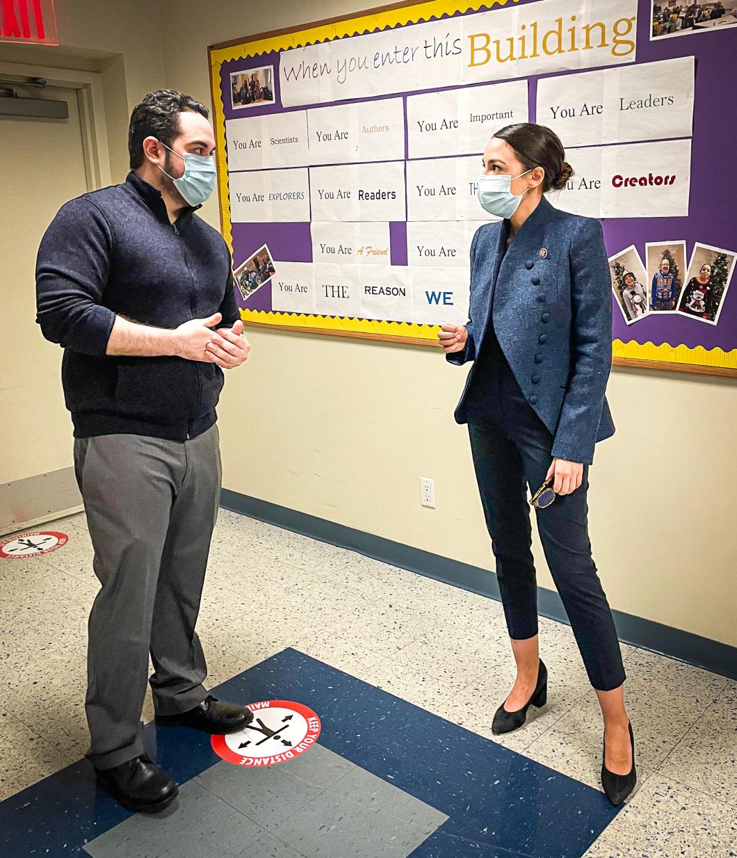 Congresswoman Ocasio-Cortez stands on the right of the picture with day hab with Juan Velazquez, Program Supervisor, on the left. Both are wearing masks.