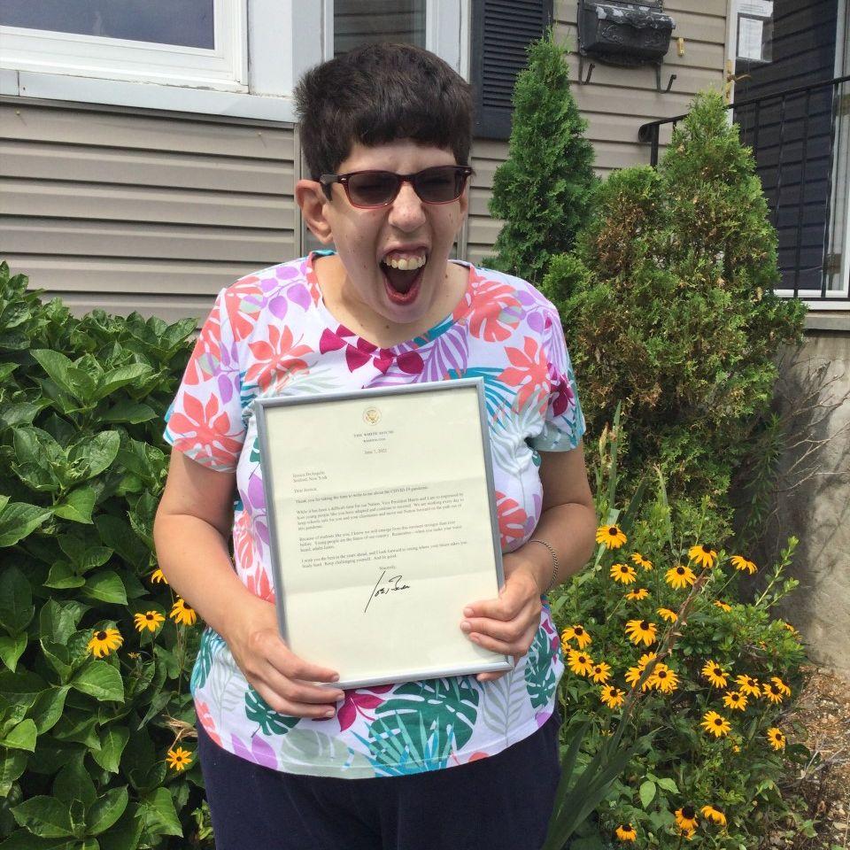 Jessica DeAngelis ecstatically holds up her framed letter from President Biden