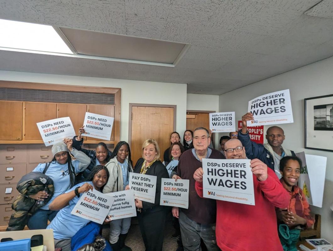 group of YAI supported people, staff, and other allies hold signs up for rally in Albany