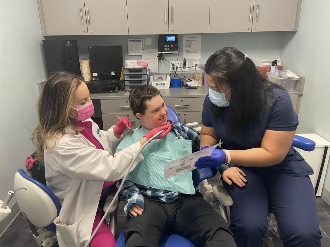 Aedan at the dentist with support OT, he is looking at her while Dr Viron goes into work on his teeth