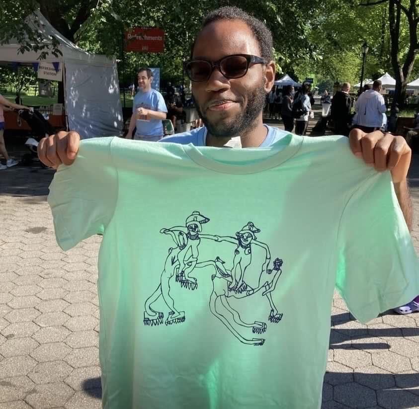 Diogeneis holding up a t-shirts at Central Park Challenge