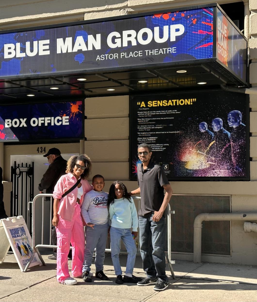 Victor and his family stand outside and pose for photo at Blue Man Group in Astor Place