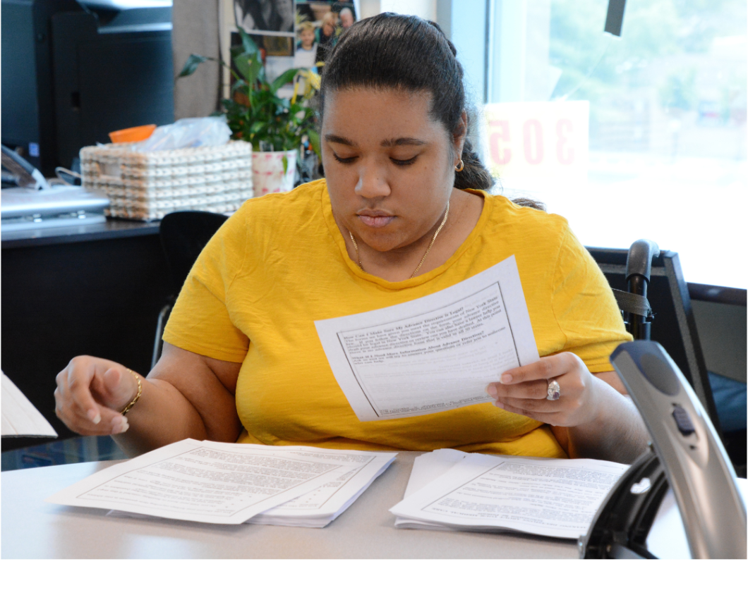 Woman sits at table and reviews documents in front of her