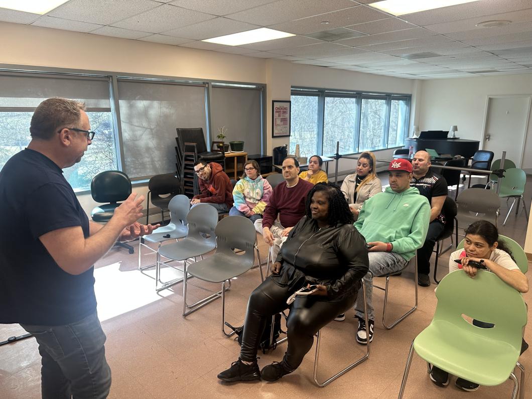 Photography group at Tarrytown sit in a room where Josh Adler is presenting