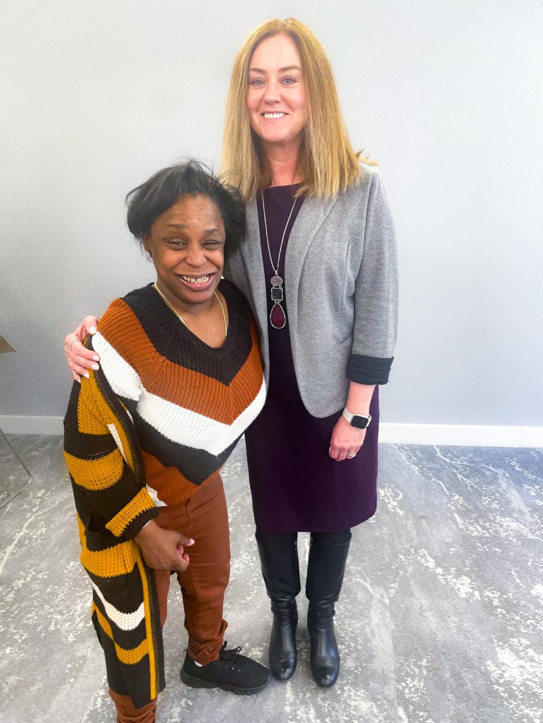 Two woman stand side by side for photo