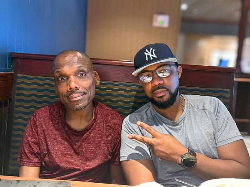 Two men sit together at a diner booth