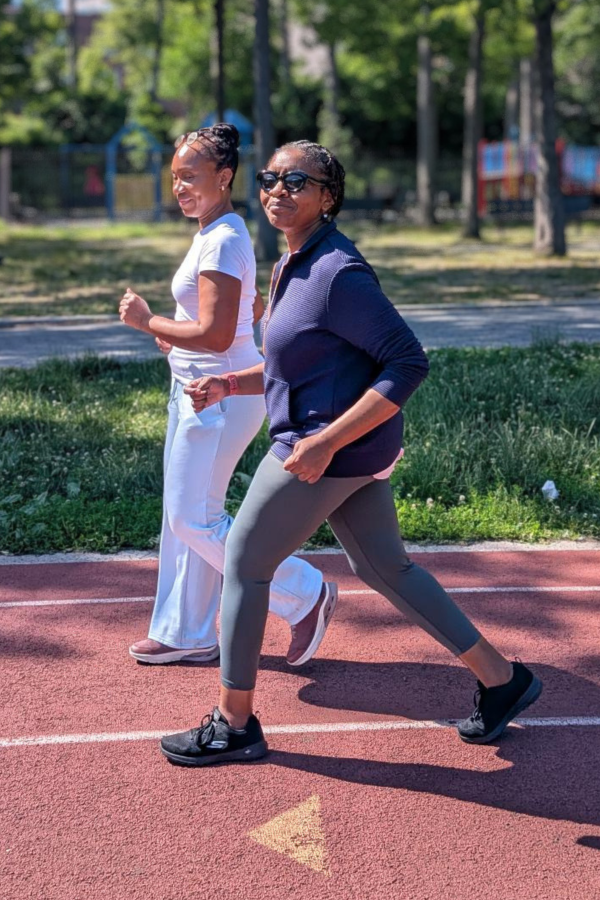 Two women walking on a sports track outdoors