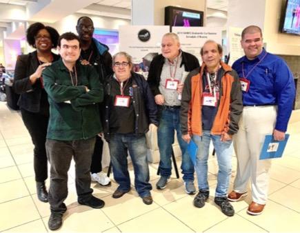 Group of seven people stand and pose for picture